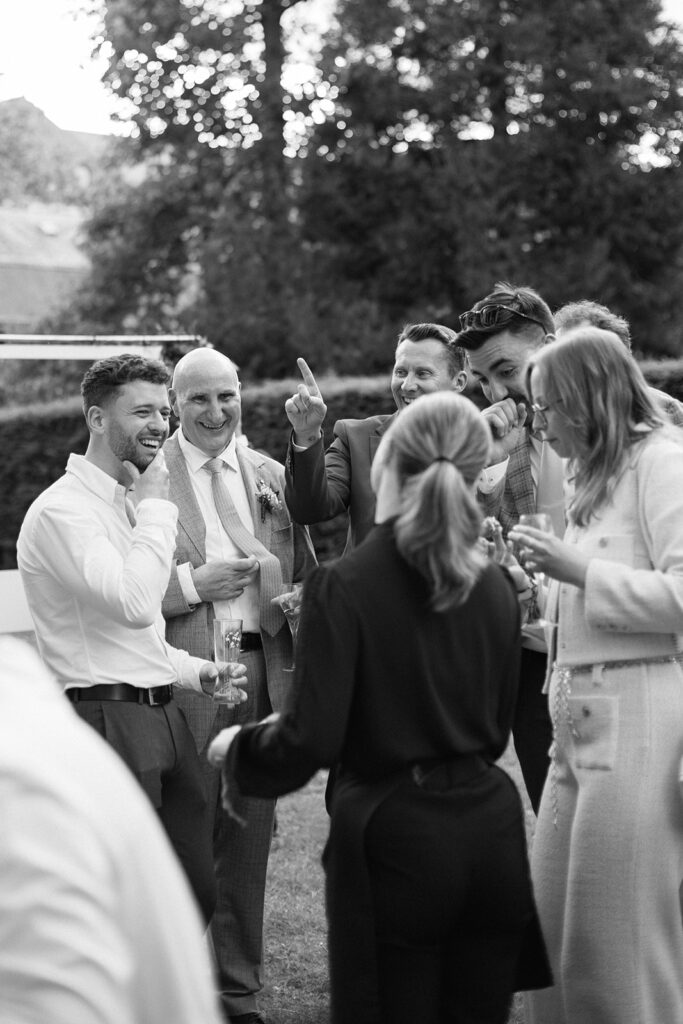 les invités du mariage lors du vin d'honneur, bonne humeur et rires en noir et blanc