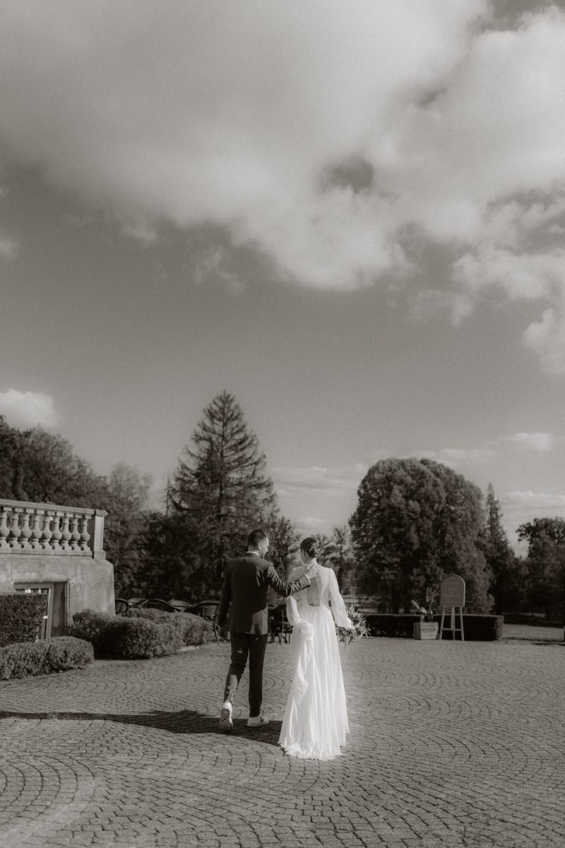 couple de mariés de dos au Chateau du Bois d'Arlon en noir et blanc